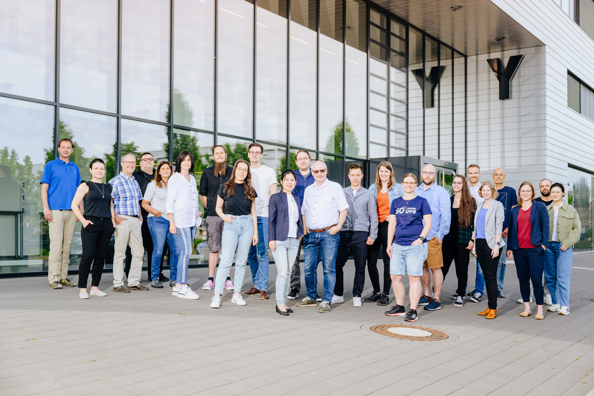 Group photo of the working group Coatings, Materials & Polymers in front of the new Y building at the Paderborn University (photographer Besim Mazhiqi)