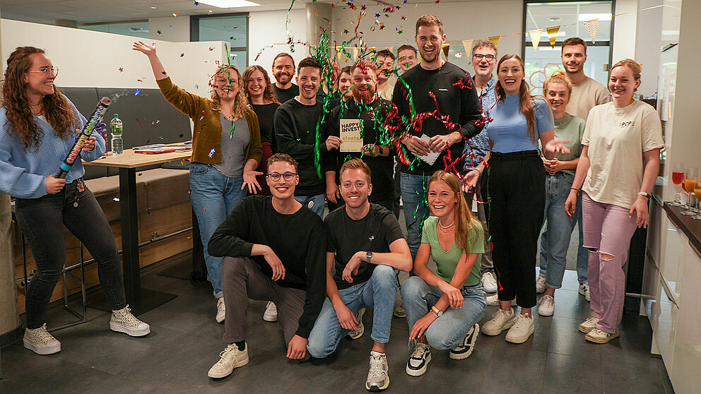 Das Team der garage33 feiert gemeinsam mit den drei Gründern des Start-ups „Steets“ ihr Investment, indem sie eine Konfetti-Kanone zünden.